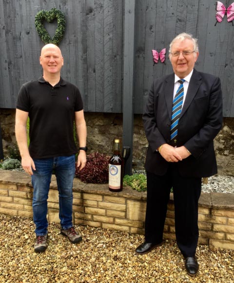Donald Easton receiving GALLON BOTTLE of 12Yr OLD MALT WHISKY from Ray Newton PM (March 2021)